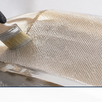 Biaxial stitched fiberglass fabric being laid into a curved boat hull repair