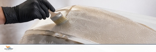 Biaxial stitched fiberglass fabric being laid into a curved boat hull repair