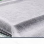 White fluffy breather cloth laid over a composite part during vacuum bagging