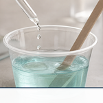 Polyester resin being stirred in a mixing cup with catalyst added by dropper