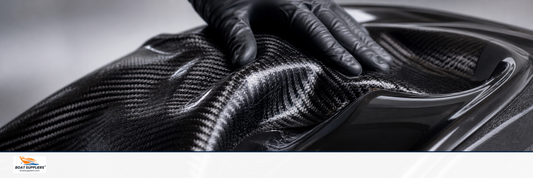 Black carbon fiber twill fabric being laid into a glossy mold