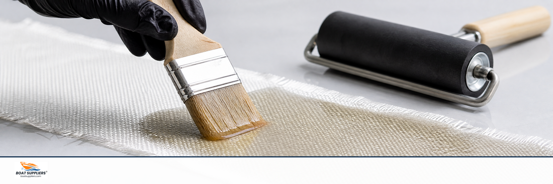 A brush saturating woven fiberglass cloth with clear resin until it turns translucent