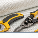 Fiberglass cutting tools including a rotary cutter and shears on a roll of cloth