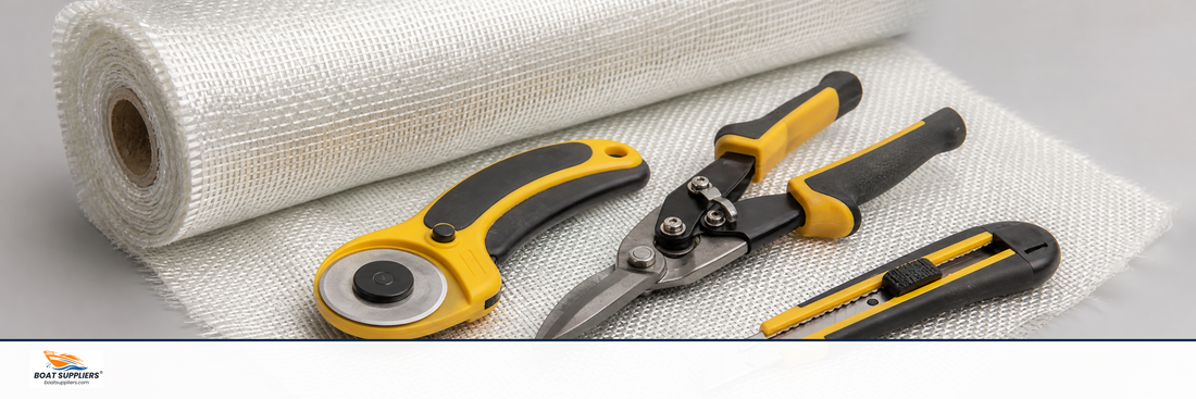 Fiberglass cutting tools including a rotary cutter and shears on a roll of cloth
