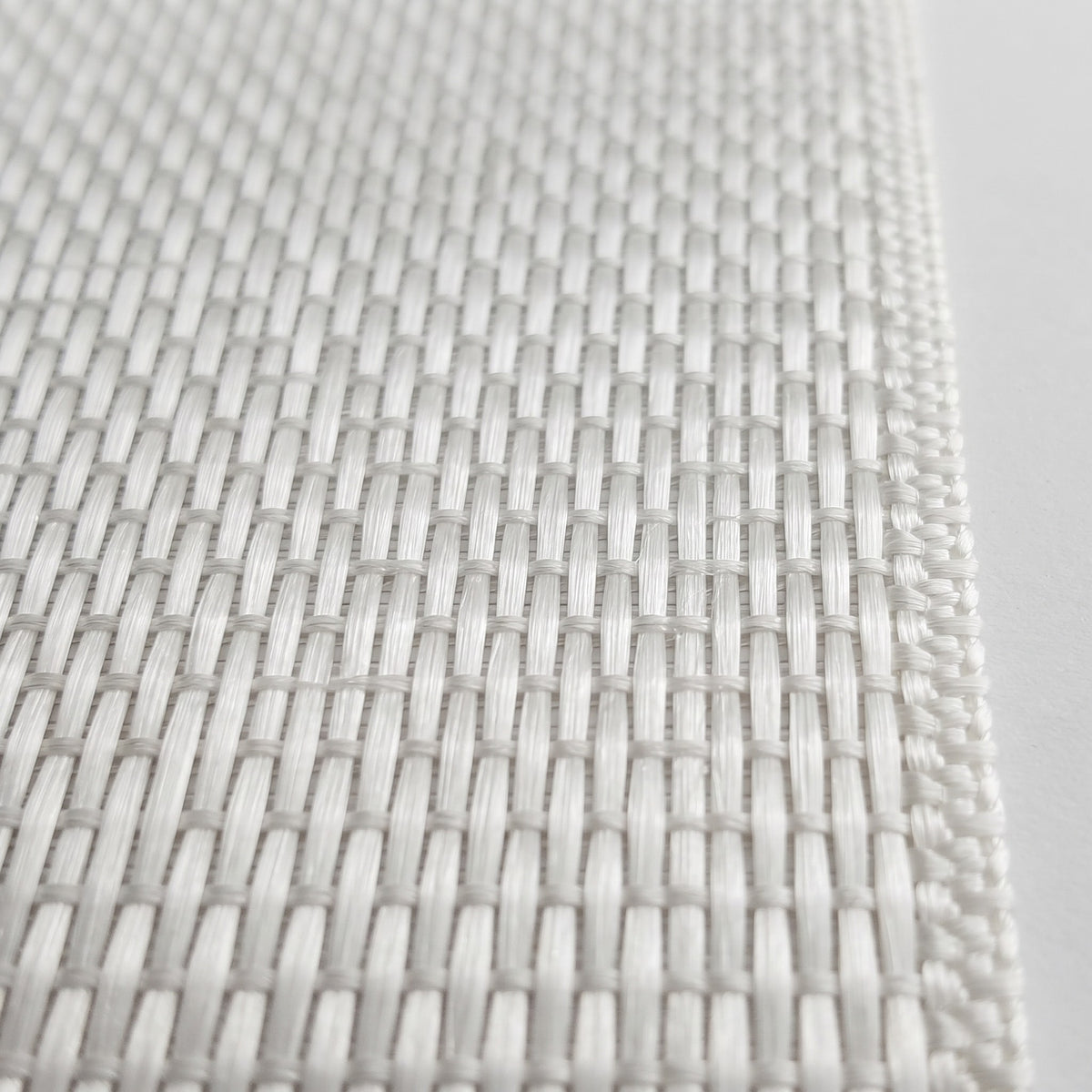 Close-up of warp unidirectional fiberglass tape weave, glass strands running the length of the tape