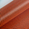 Angled close-up of 5.5oz carbon Kevlar hybrid fabric, 2x2 twill weave of red Kevlar and black carbon fiber tows.