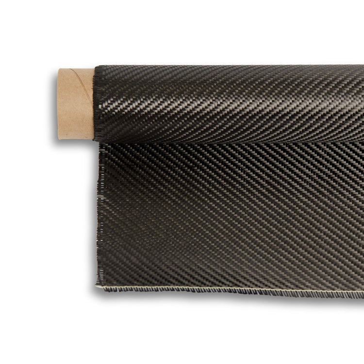 5.7oz 3K carbon fiber twill fabric partly unrolled from its cardboard core, 2x2 diagonal weave across the width.