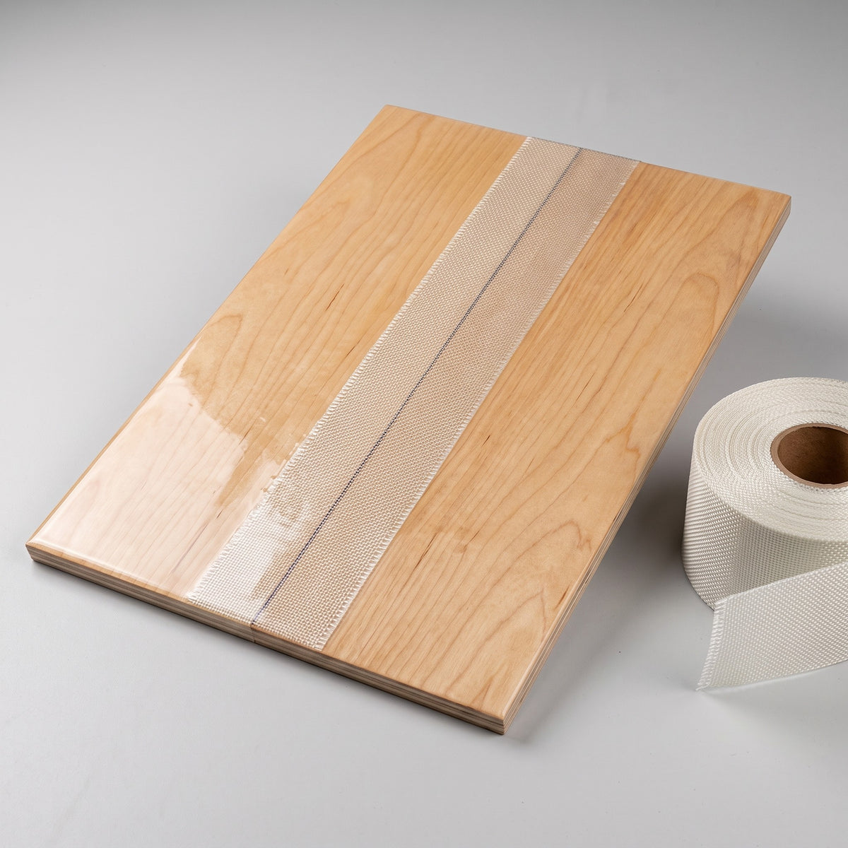 Plywood seam reinforced with woven fiberglass cloth tape under clear epoxy
