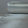 Low side view of a roll of 8.5oz 2x2 twill fiberglass cloth with the E-glass fabric unrolled across a gray work surface in front of it