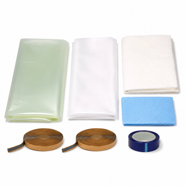 Large vacuum bagging kit laid out on white: five yard bundles of translucent green nylon bagging film, white peel ply and off-white breather cloth, blue perforated release film, two rolls of yellow sealant tape and a roll of green polyester flash tape
