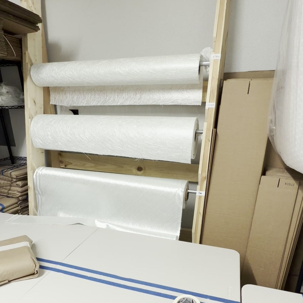 Fiberglass rolls on the rack beside the cutting table