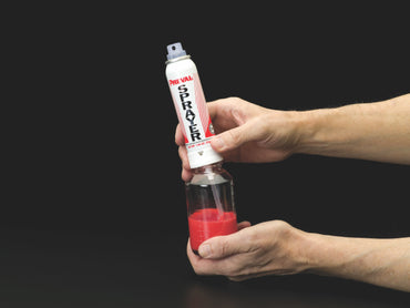 Attaching the Preval power unit to the glass jar filled with red paint