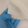 Gloved hand holding the cut edge of satin weave fiberglass cloth